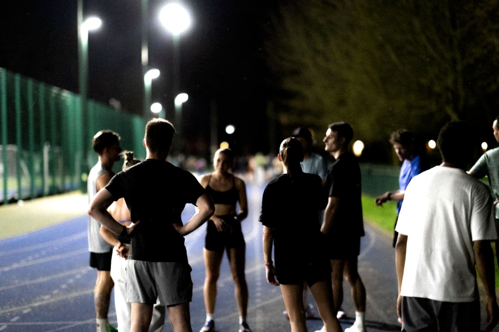 MXO athletes training together on a track at night